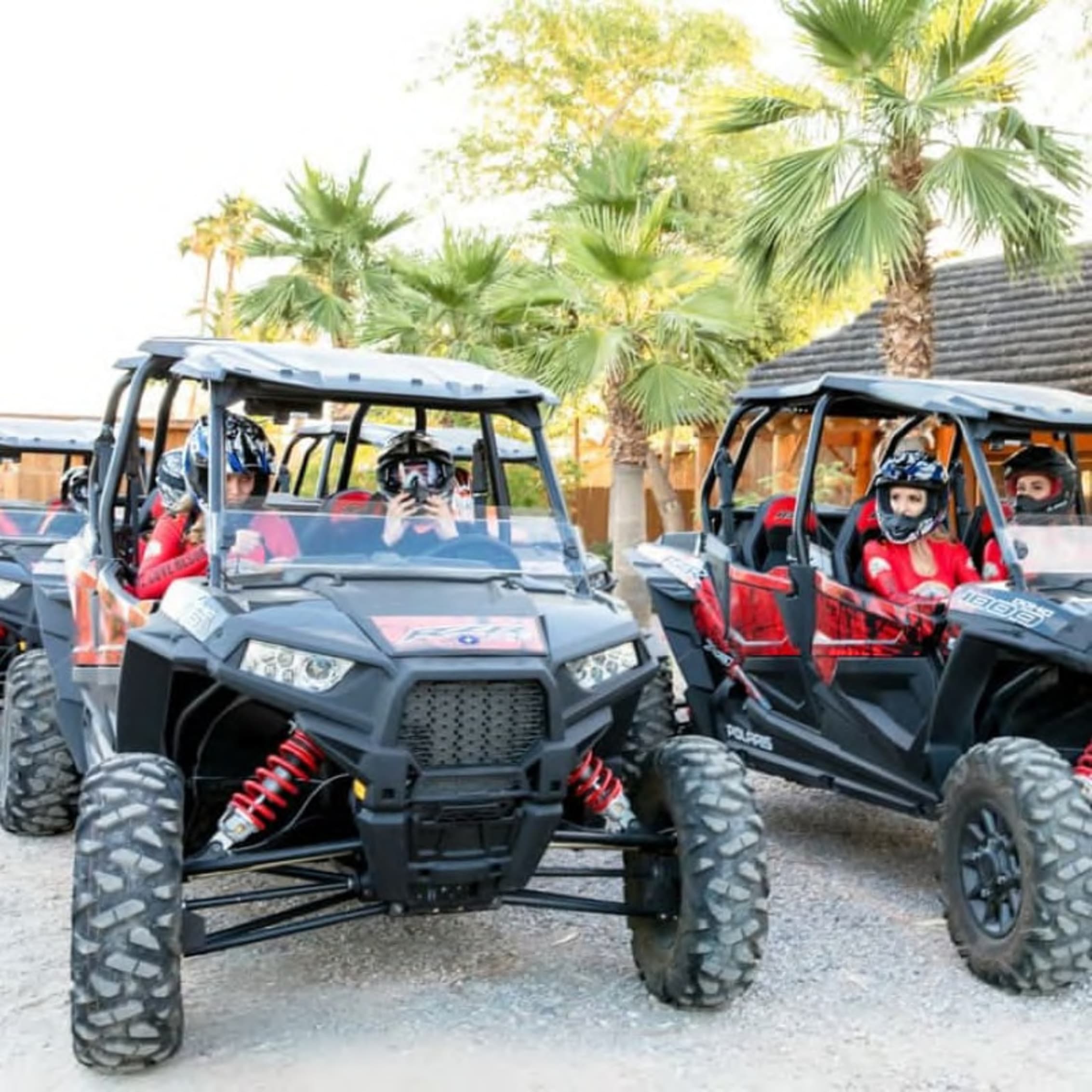 Enthusiasts in safety gear driving a fleet of Polaris off-road vehicles, ready to explore.