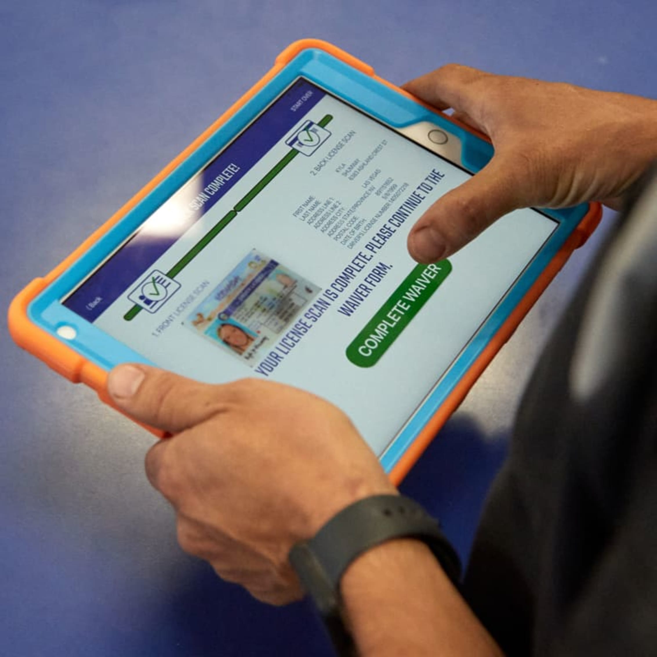 Person using a tablet for a secure check-in process, indicating reduced risk.