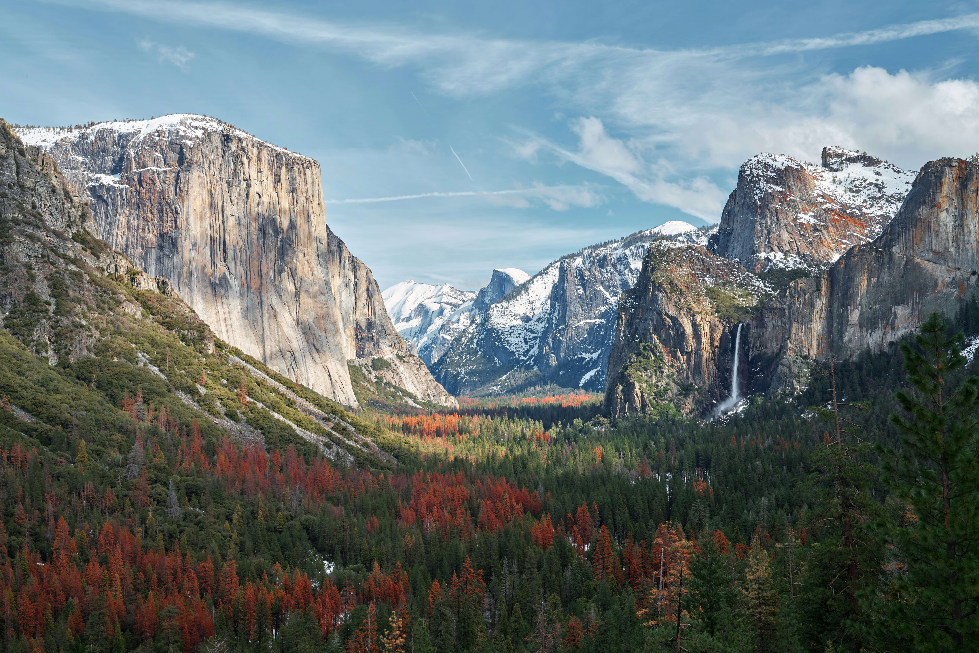 Breathtaking view of Yosemite National Park with iconic granite cliffs and vibrant autumn foliage.