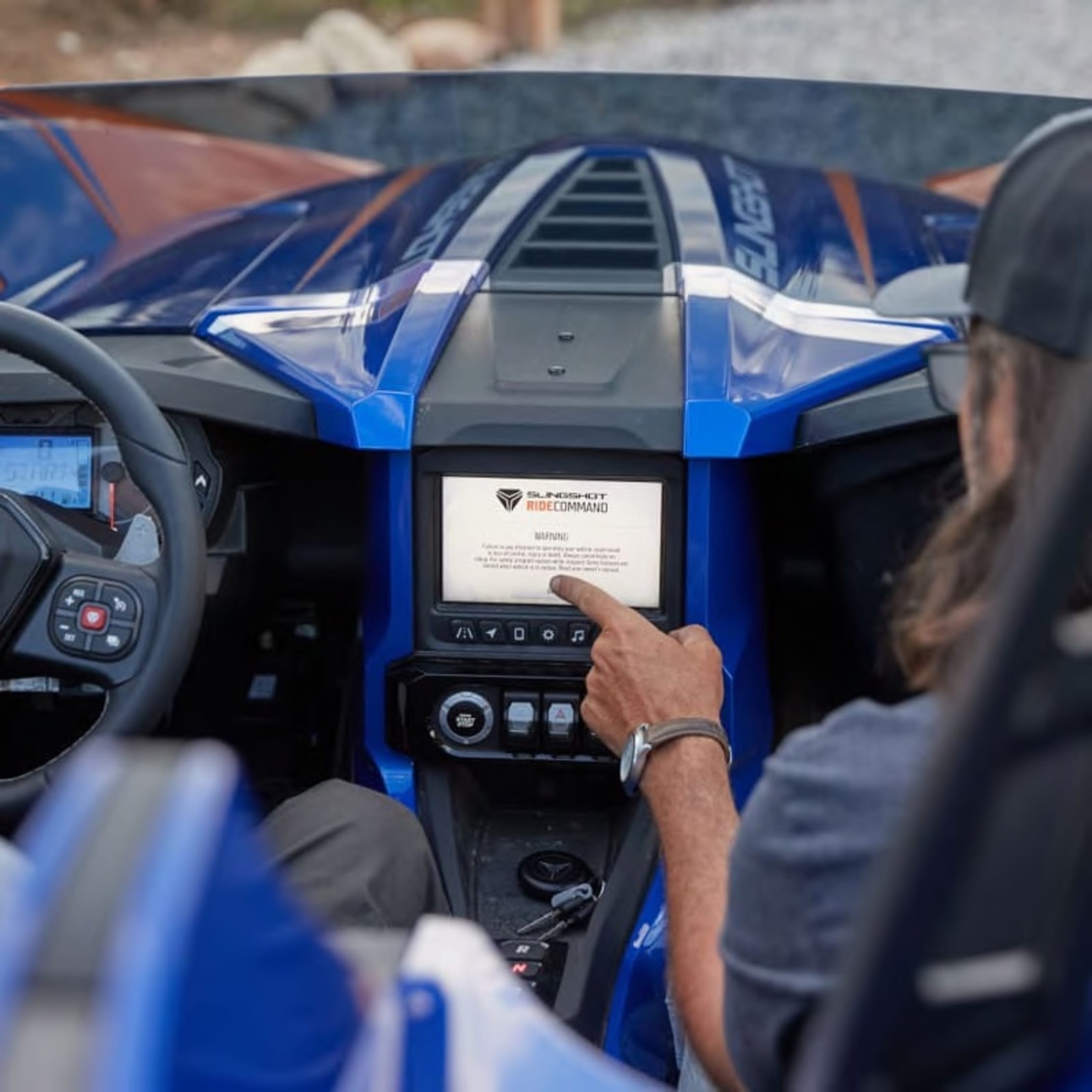 Person in a vehicle touching the RIDE COMMAND system for safety training.