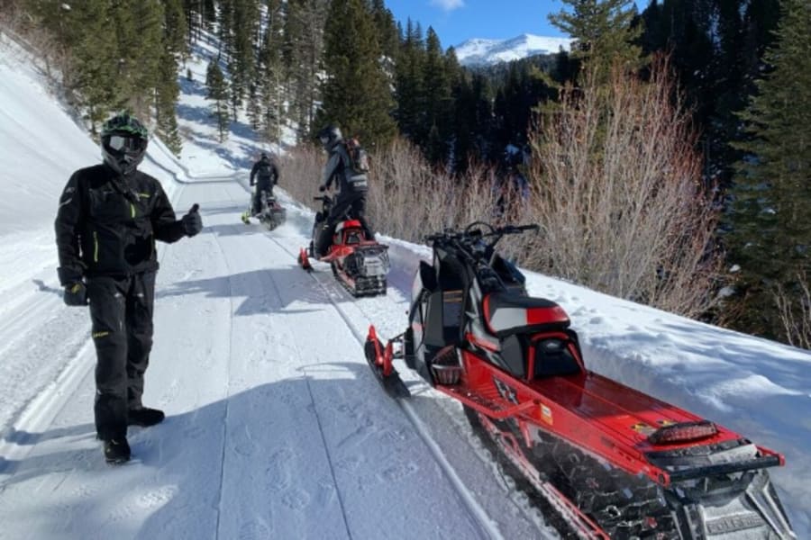 Red Polaris snowmobiles on trail in Idaho