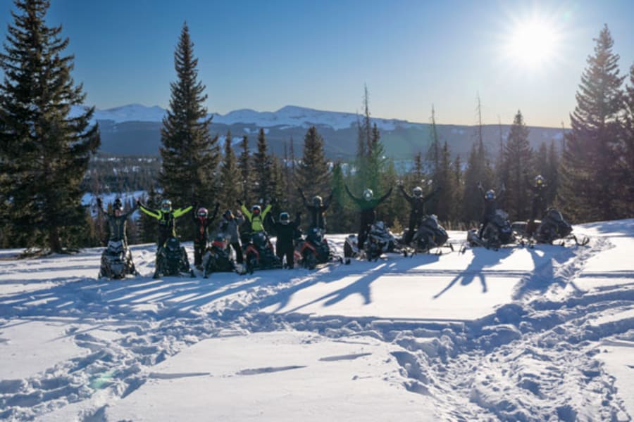 Snowmobilers lined up with arms up