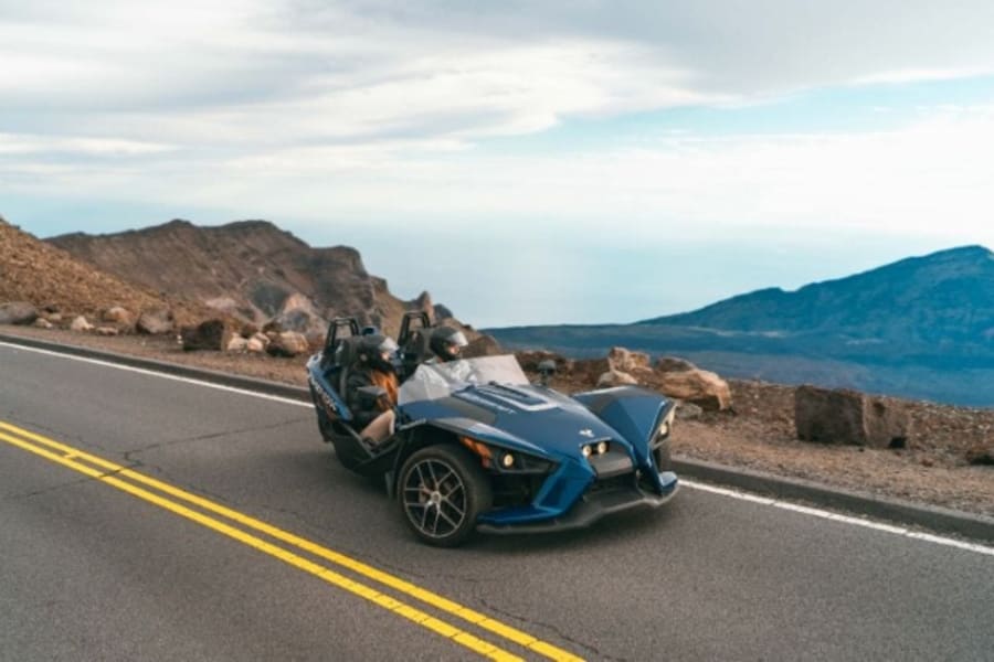 Two people in a Polaris Slingshot on Hawaiian highway