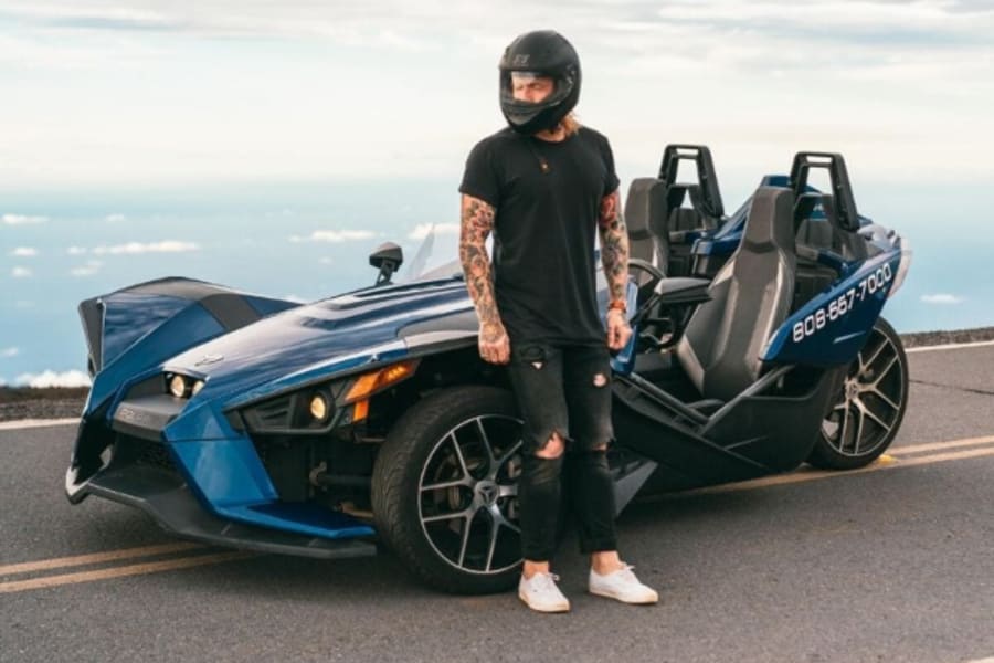 Man standing by Polaris Slingshot in Hawaii