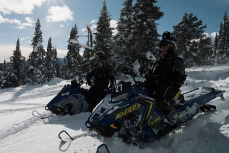 Two people on Polaris snowmobiles near Jackman, Maine