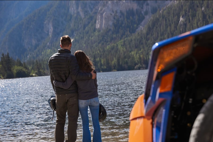 A couple by a Colorado river with a Polaris Slingshot
