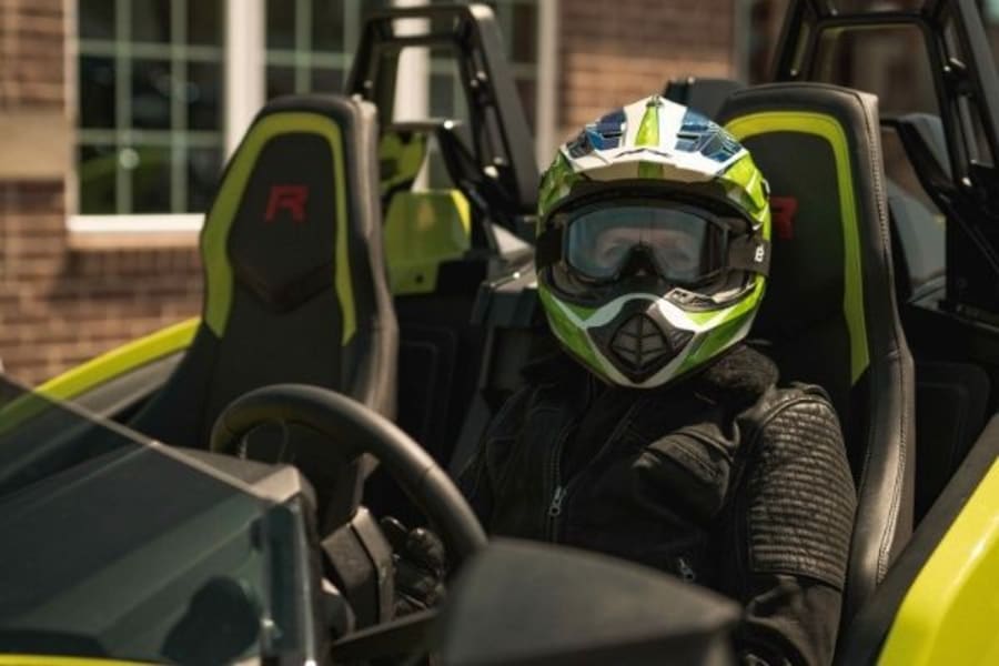 Helmeted woman in Polaris Slingshot