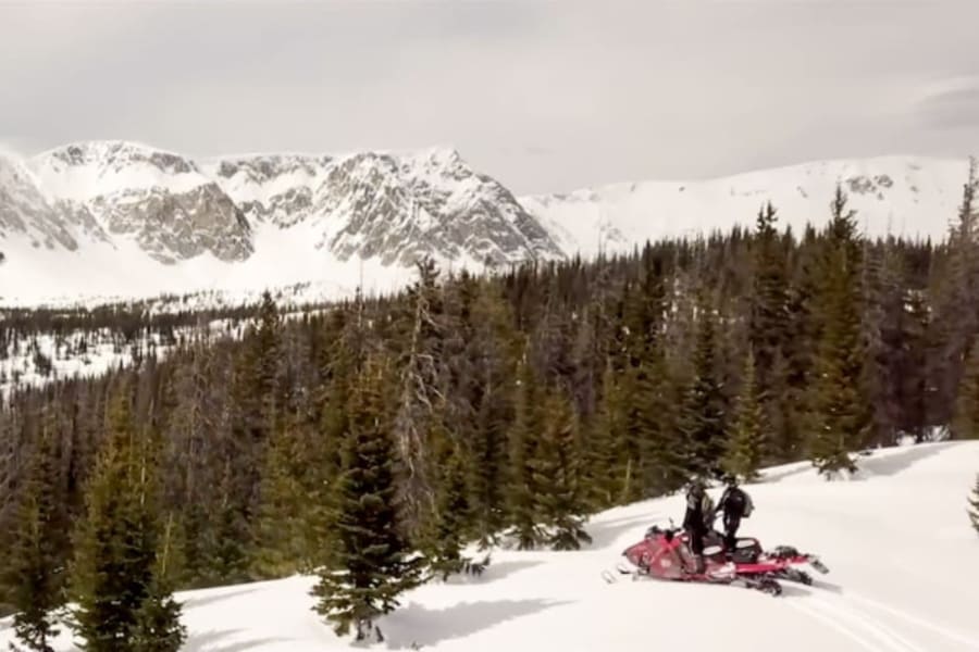 Snowmobilers looking at Wyoming mountain view