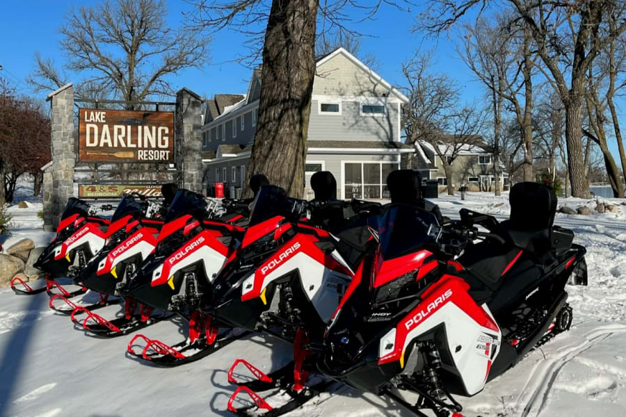 Polaris snowmobiles parked in front of Lake Darling Resort