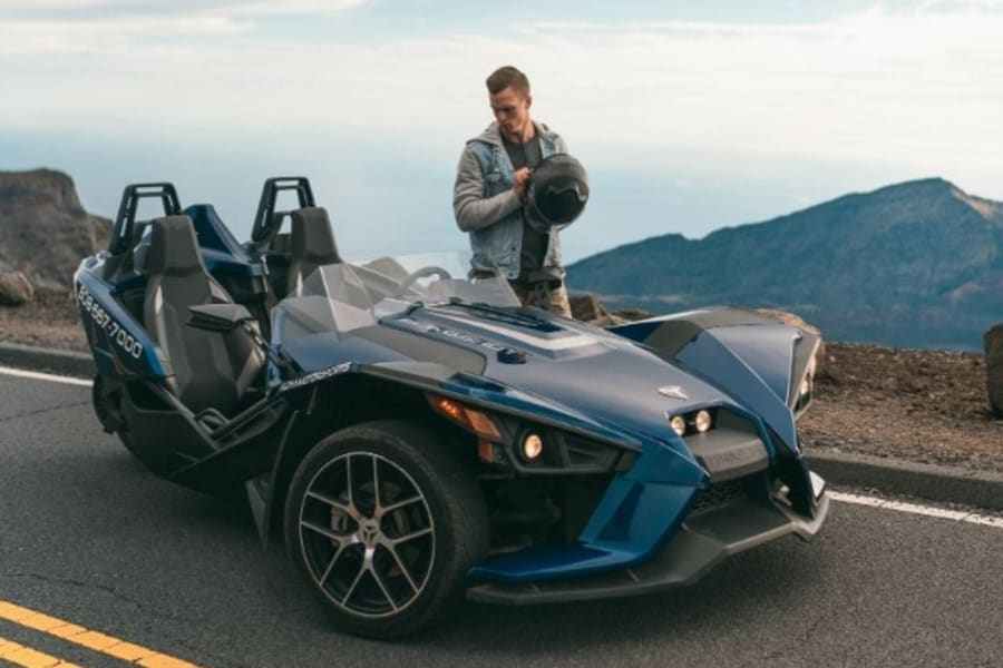 Man standing by Polaris Slingshot in Hawaii