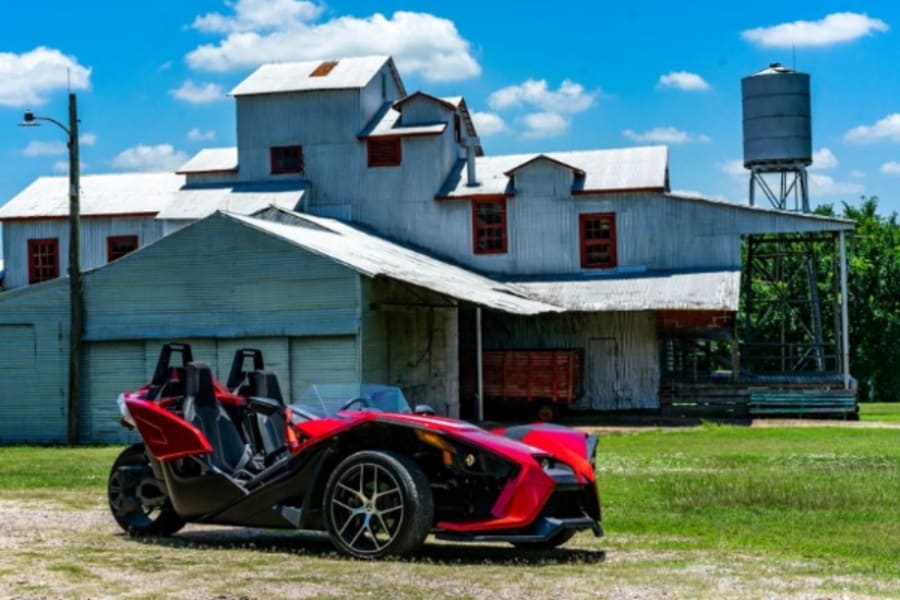 Polaris Slingshot in front of rural Texas building.