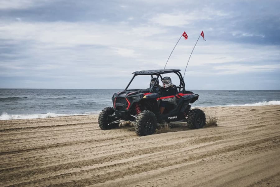 Two people in Polaris RZR on Oregon beach