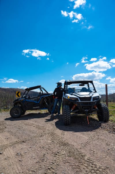 Two Polaris side by sides and a driver