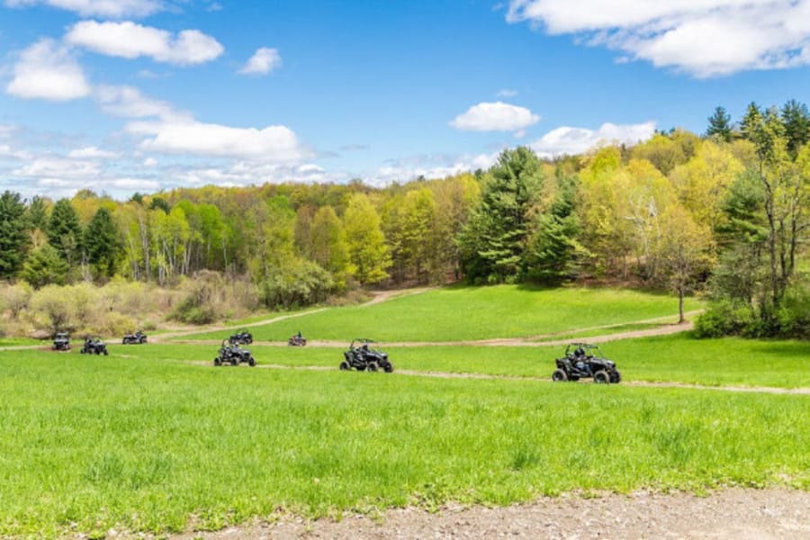 Polaris side by sides driving along hillside trail