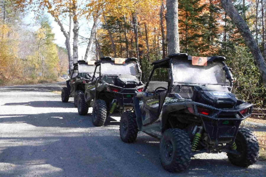 Polaris side by sides in a row on trail near Jackman, Maine