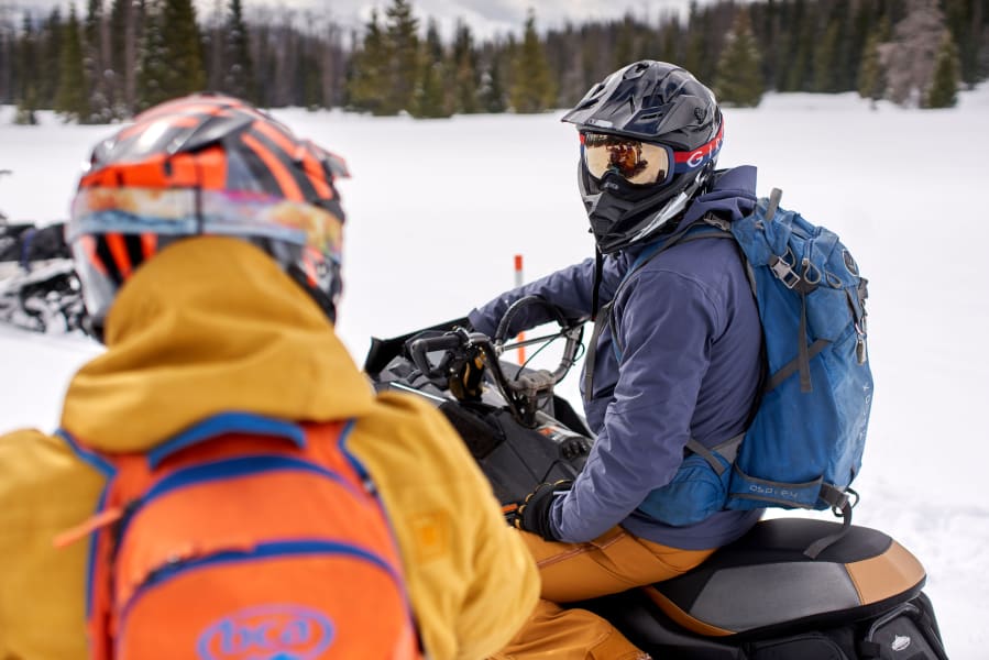 Two snowmobilers talking