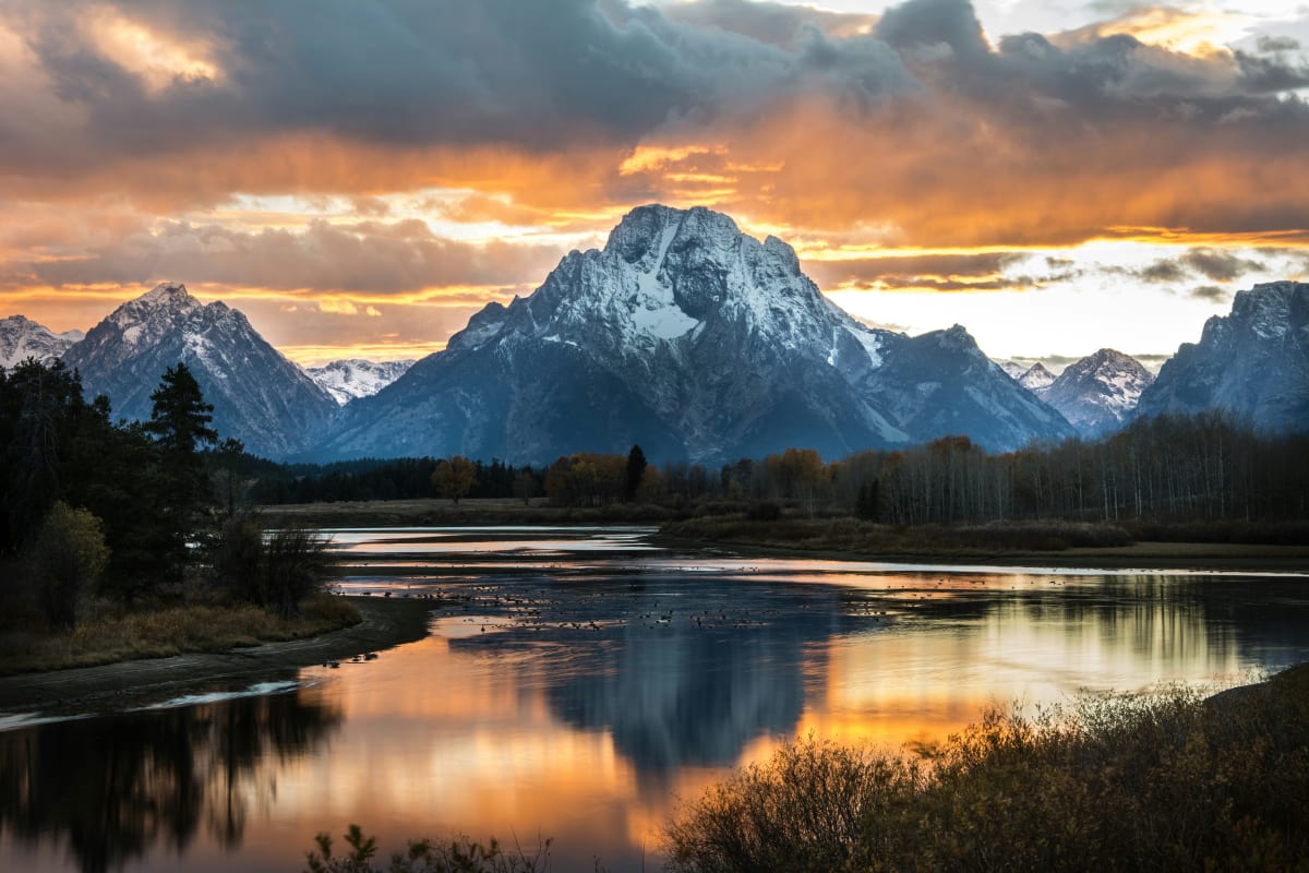 Sunset over Grand Teton National Park with reflection in river and majestic mountains