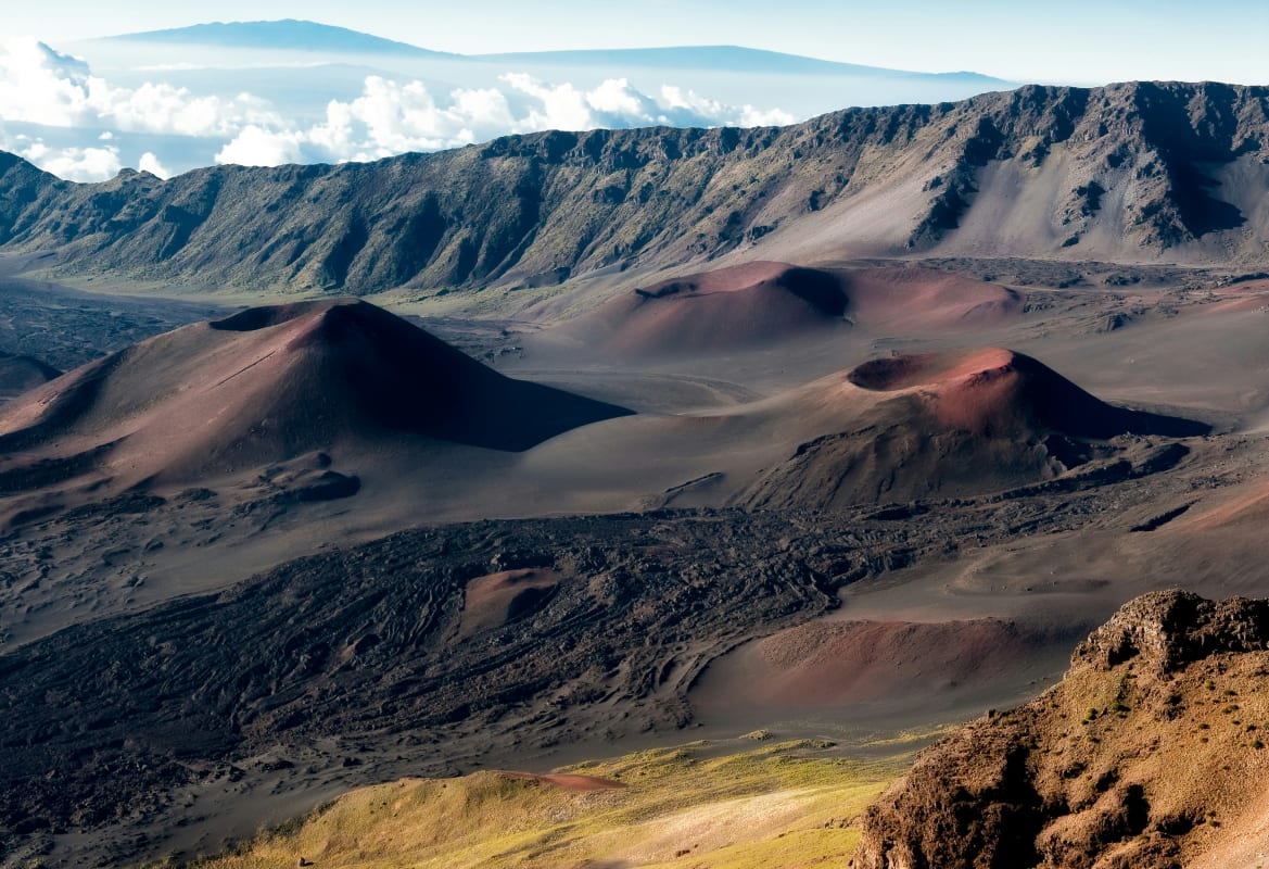 Aerial view of Haleakala National Park showcasing the volcanic landscape with craters and diverse colors.
