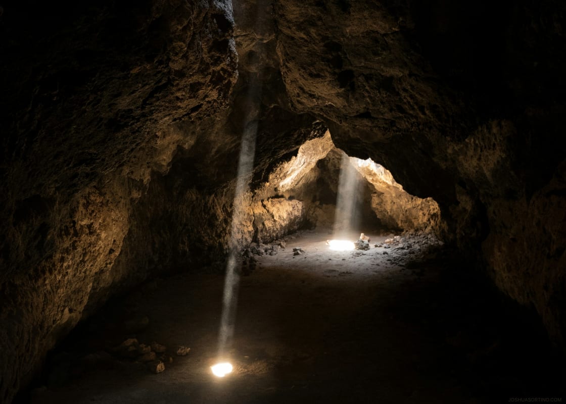 Shafts of sunlight breaking through the entrance of Mammoth Cave at a national park