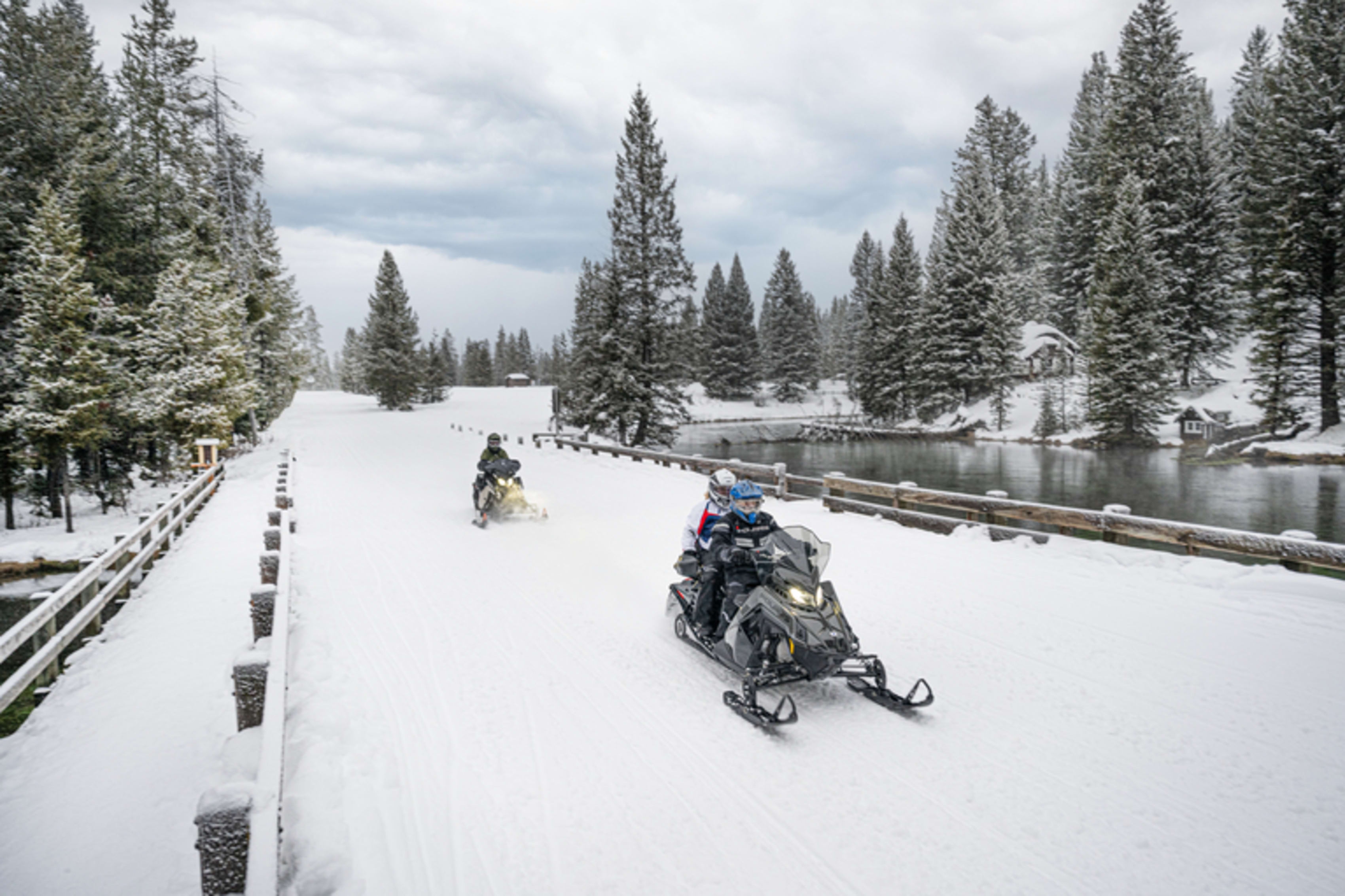 Two snowmobilers standing.