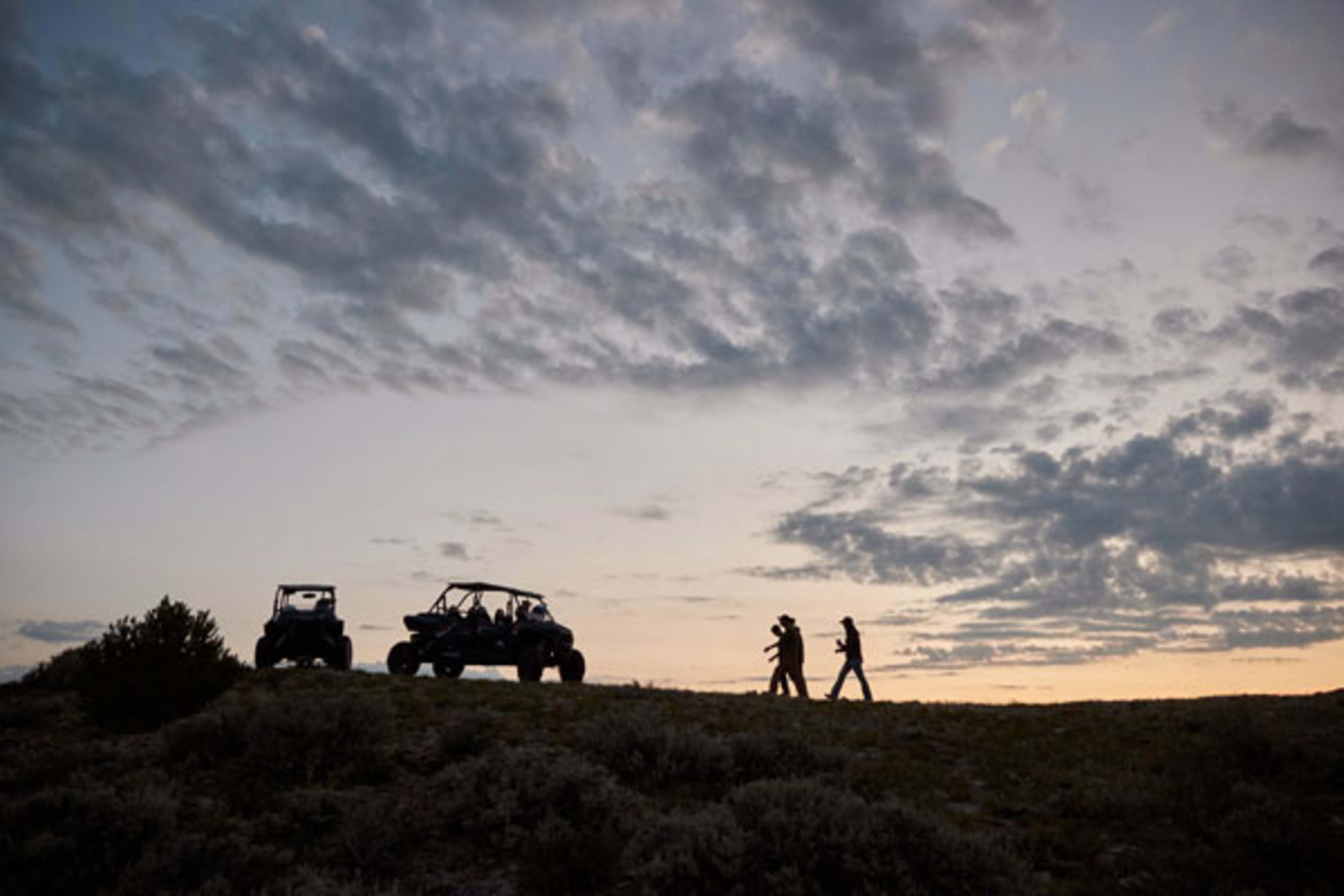 Sunset silhouette of ORV riders